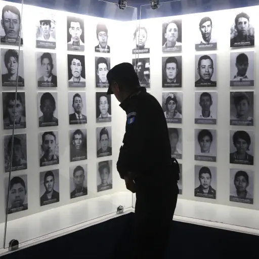 ACOMPAÑA CRÓNICA - GU2004. RABINAL, BAJA VERAPAZ (GUATEMALA), 29/08/2017.- Fotografía del 27 de marzo de 2017, de un agente de policía mientras observa los rostros de las víctimas de una masacre en varias comunidades expuestos en la sala del Museo Comunit