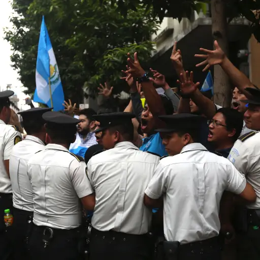 GU5021. CIUDAD DE GUATEMALA (GUATEMALA), 15/09/2017.- Policías contienen a manifestantes que insultan a los diputados guatemaltecos hoy, viernes 15 de septiembre de 2017, a la entrada del Congreso en Ciudad de Guatemala (Guatemala). Manifestantes en las a