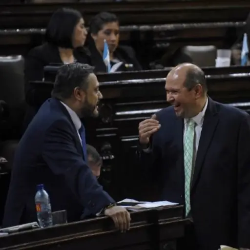 Guatemalan deputies Javier Hernandez (L) and Orlando Blanco chat before the voting for maintaining or not the immunity of Guatemalan President Jimmy Morales accused of corruption during a session of the Congress in Guatemala City on September 11, 2017.Gu