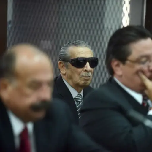 Former Guatemalan de facto president (1982-1983), retired General Jose Efrain Rios Montt, 86, (C) is seen wearing dark glasses prescribed after his cataract surgery, during a court hearing in Guatemala City on November 19, 2013. A tribunal confirmed that 