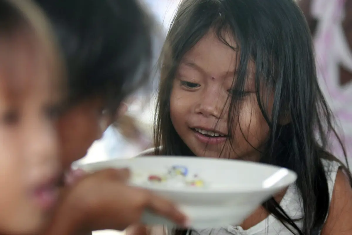 FRM01 MANILA (FILIPINAS) 08/10/2011.- Varios niños asisten a un comedor que forma parte de un programa de alimentos en una localidad costera del entorno de Manila (Filipinas) hoy, sábado 8 de octubre de 2011. Los tifones "Nesat" y "Nalgae" golpearon el no