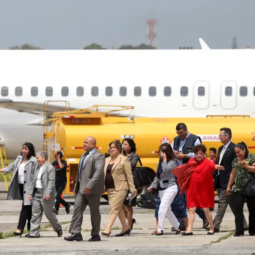 GU5001. CIUDAD DE GUATEMALA (GUATEMALA), 02/09/2016.- Una comitiva del Servicio de Inmigración y Control de Aduanas de Estados Unidos observa a deportados guatemaltecos bajar de un avión proveniente de Meza, Arizona (EEUU), en la Fuerza Aérea de Ciudad de