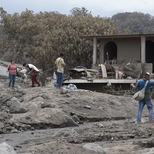 GU106. SAN MIGUEL DE LOS LOTES (GUATEMALA), 07/06/2018.- Un grupo de personas retira los escombros de las viviendas parcialmente enterradas debido a la erupción del Volcán de Fuego el pasado domingo, en un intento por encontrar a algunos de sus familiares
