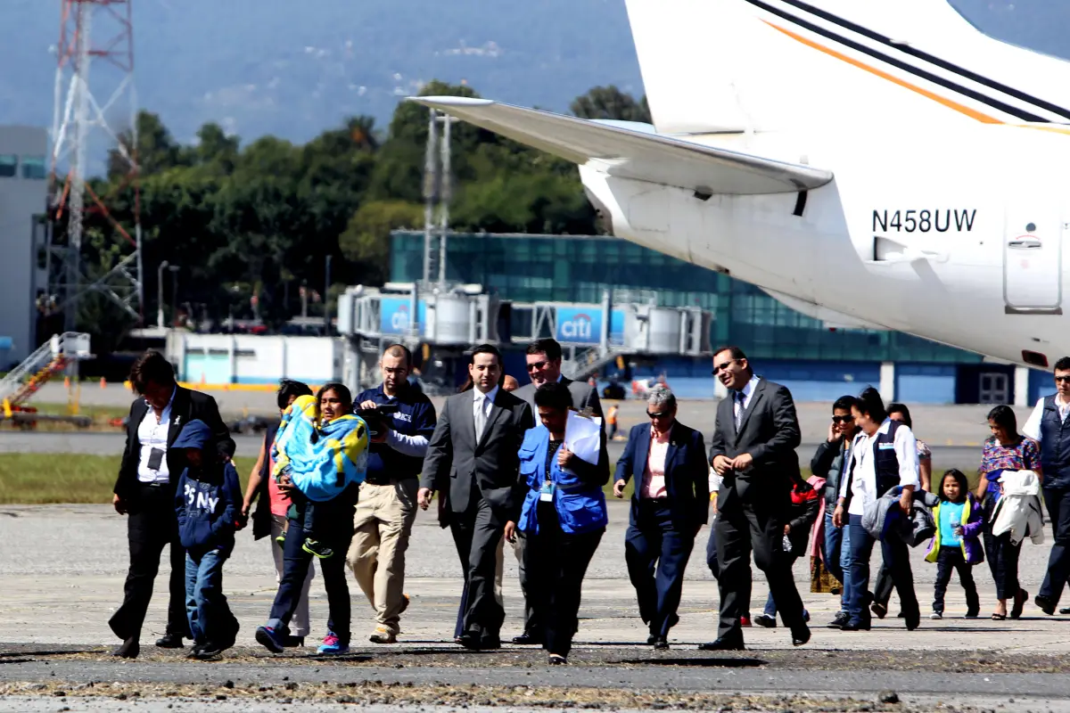 GU3000. CIUDAD DE GUATEMALA (GUATEMALA), 06/01/2016.- Catorce personas, cuatro madres y 10 niños deportados de Estados Unidos hacia Guatemala, caminan por la pista del aeropuerto internacional La Aurora de Guatemala hoy, miércoles 6 de enero de 2016. Las 