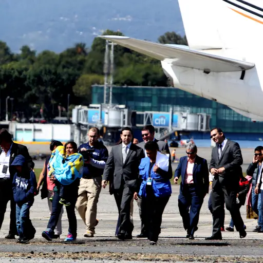 GU3000. CIUDAD DE GUATEMALA (GUATEMALA), 06/01/2016.- Catorce personas, cuatro madres y 10 niños deportados de Estados Unidos hacia Guatemala, caminan por la pista del aeropuerto internacional La Aurora de Guatemala hoy, miércoles 6 de enero de 2016. Las 