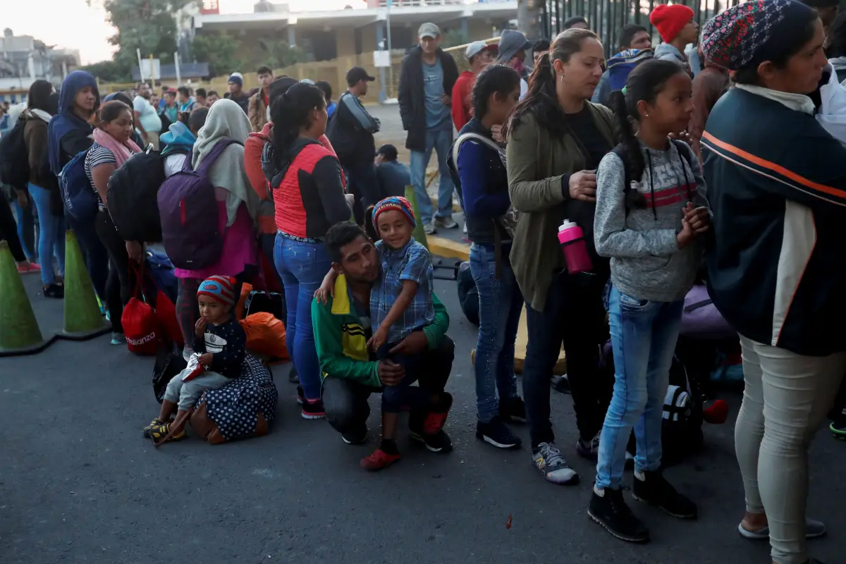 GU6006. TECÚN UMÁN (GUATEMALA), 19/01/2019.- Migrantes centroamericanos, parte de la caravana de migrantes con destino hacia los Estados Unidos, hacen fila este sábado en la entrada de la frontera entre Guatemala y México, en Tecún Umán (Guatemala). Cient