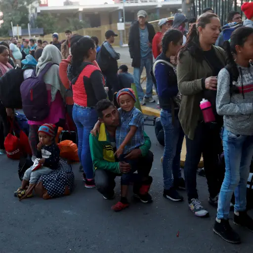 GU6006. TECÚN UMÁN (GUATEMALA), 19/01/2019.- Migrantes centroamericanos, parte de la caravana de migrantes con destino hacia los Estados Unidos, hacen fila este sábado en la entrada de la frontera entre Guatemala y México, en Tecún Umán (Guatemala). Cient