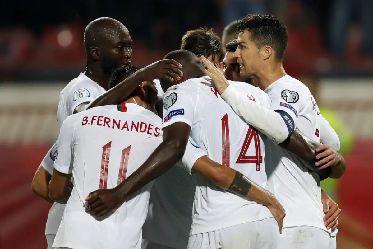 Portugal's Cristiano Ronaldo (R) celebrates a goal with his teammates William Carvalho (L) and Bruno Fernandes (2ndL) during the Euro 2020 football qualification match between Serbia and Portugal in Belgrade, on September 7, 2019. (Photo by PEDJA MILOSAVL