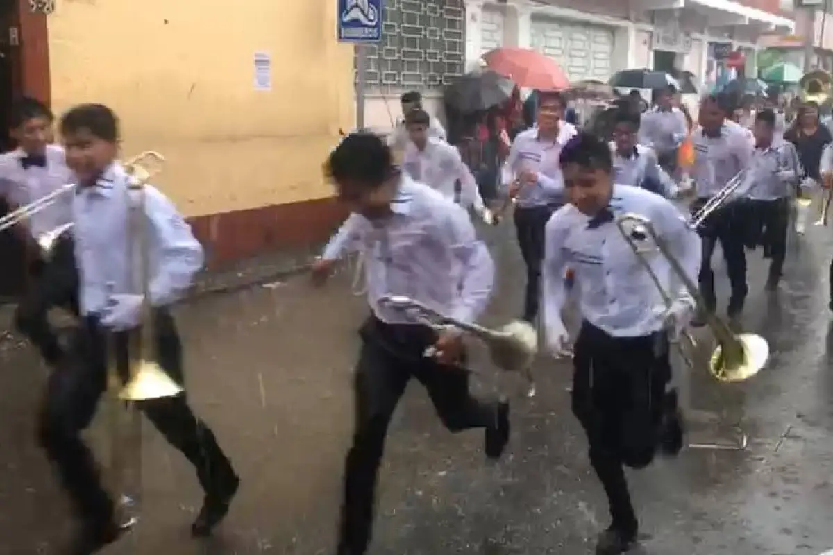 Participantes de desfile son sorprendidos por la lluvia en Totonicapán