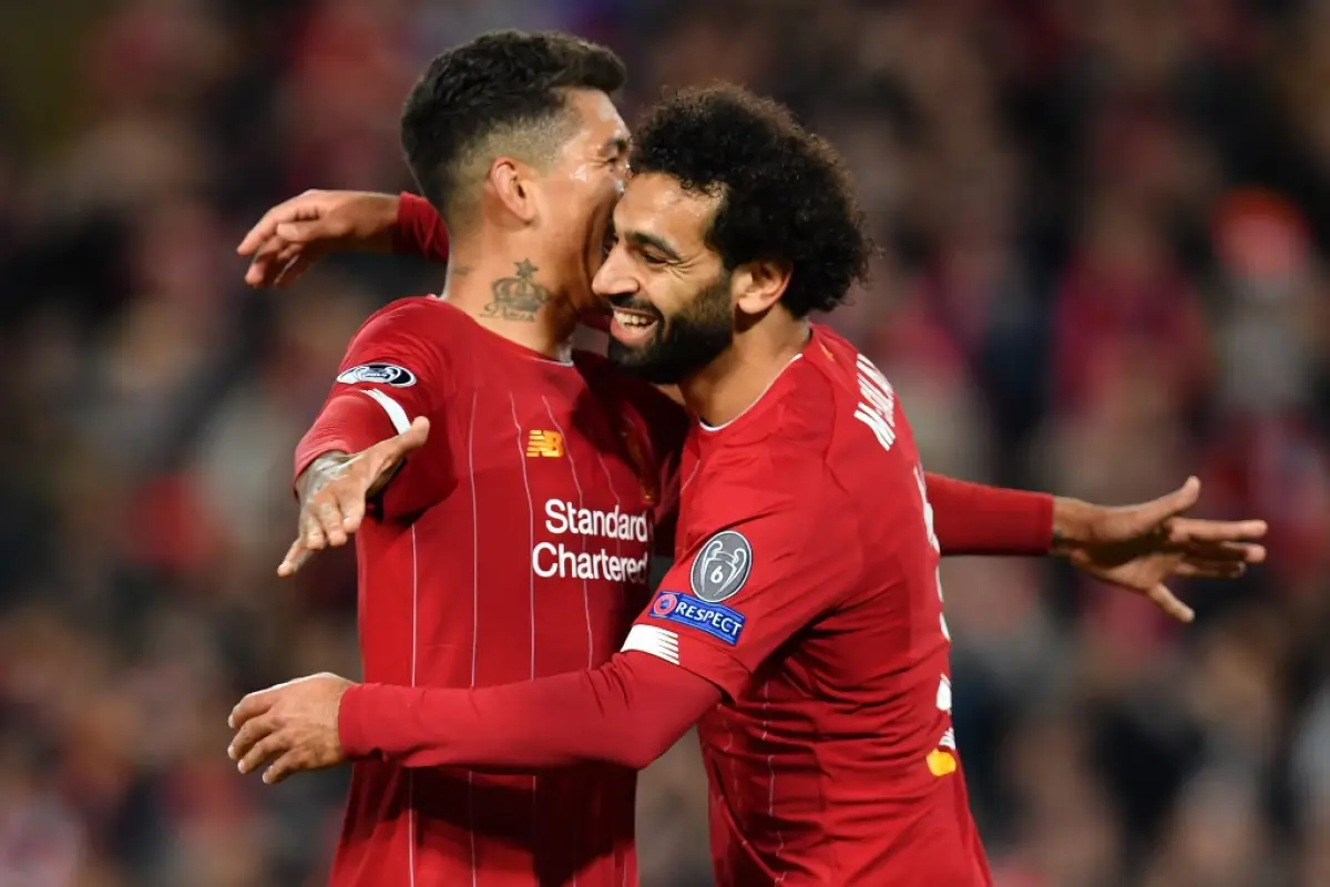 Liverpool's Egyptian midfielder Mohamed Salah (R) celebrates with Liverpool's Brazilian midfielder Roberto Firmino after scoring their fourth goal during the UEFA Champions league Group E football match between Liverpool and Salzburg at Anfield in Liverpo