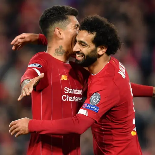 Liverpool's Egyptian midfielder Mohamed Salah (R) celebrates with Liverpool's Brazilian midfielder Roberto Firmino after scoring their fourth goal during the UEFA Champions league Group E football match between Liverpool and Salzburg at Anfield in Liverpo