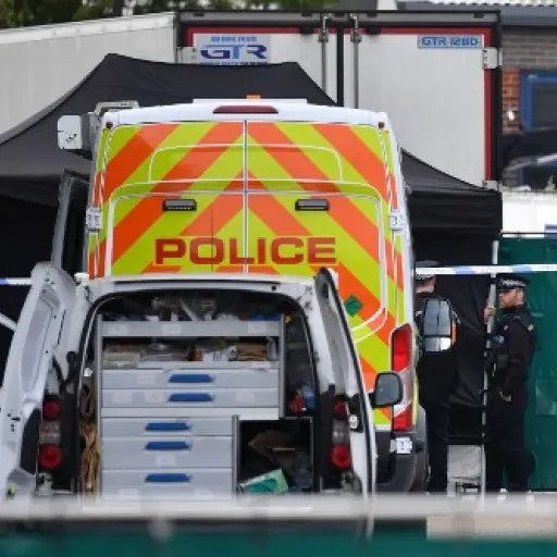 British Police officers in forsensic suits work near a lorry, believed to have originated from Bulgaria, and found to be containing 39 dead bodies, as they work inside a police cordon at Waterglade Industrial Park in Grays, east of London, on October 23, 