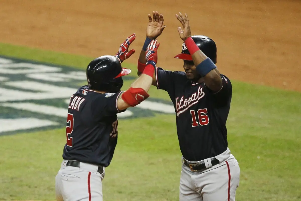 HOUSTON, TEXAS - OCTOBER 23: Adam Eaton #2 of the Washington Nationals is congratulated by his teammate Victor Robles #16 after hitting a two-run home run against the Houston Astros during the eighth inning in Game Two of the 2019 World Series at Minute M