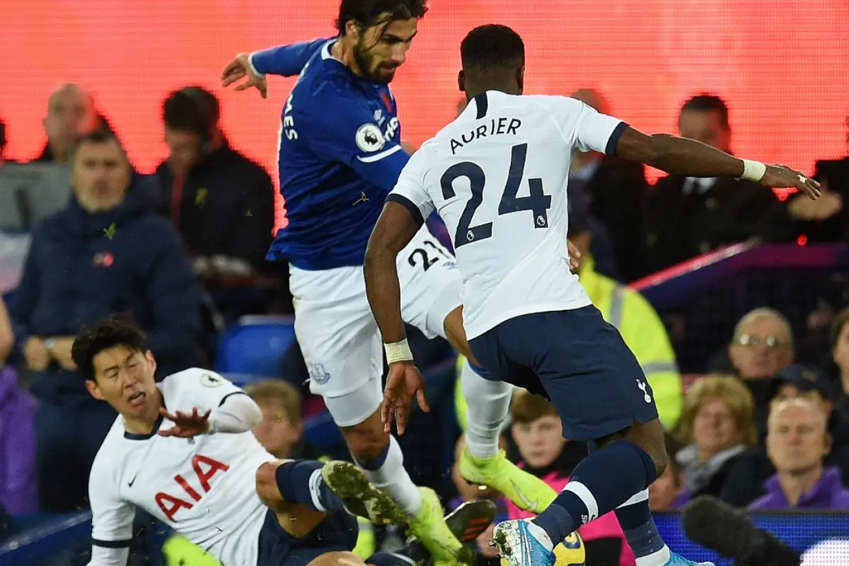 Everton's Portuguese midfielder André Gomes (C) is brought down in a challenge by Tottenham Hotspur's South Korean striker Son Heung-Min (L floor) as Tottenham Hotspur's Ivorian defender Serge Aurier (R) comes in to challenge for the ball leading to an in