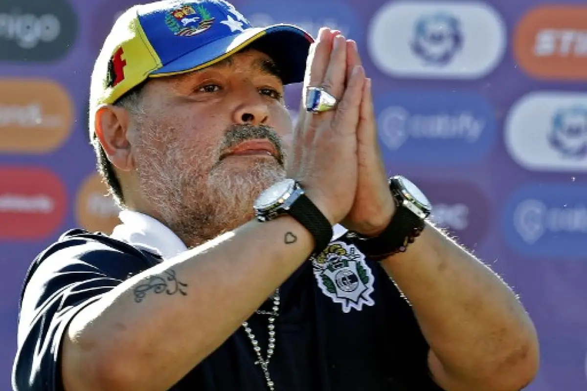 (FILES) In this file photo taken on November 02, 2019, Gimnasia y Esgrima team coach Diego Armando Maradona gestures to supporters as he leaves the field after an Argentina First Division Superliga football match against Estudiantes, at El Bosque stadium,