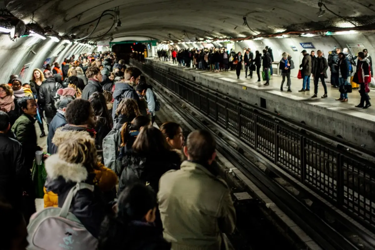 Commuters wait for a train in Chatelet subway station in Paris, on December 16, 2019, during a strike of Paris' public transports operator RATP and of the French state railway company SNCF employees over French government's plan to overhaul the country's 