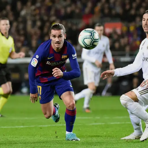 Barcelona's French forward Antoine Griezmann (C) and Real Madrid's Spanish defender Sergio Ramos eye the ball during the 