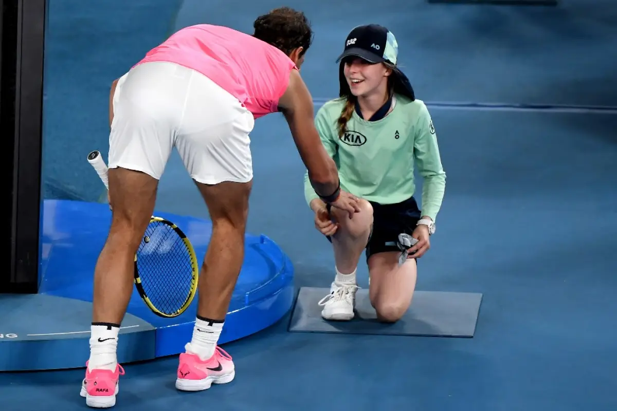 Spain's Rafael Nadal speaks with a ball kid who was hit by the ball during the men's singles match against Argentina's Federico Delbonis on day four of the Australian Open tennis tournament in Melbourne on January 23, 2020. (Photo by Manan VATSYAYANA / AF