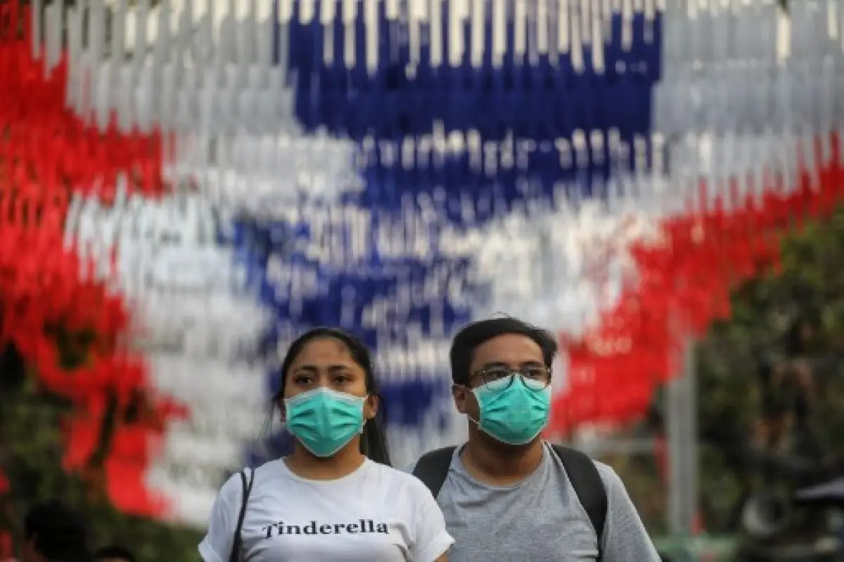 People wearing protective facemasks browse stalls at the Chatuchak weekend market in Bangkok on February 8, 2020, as tourist numbers drop across the region due to the novel coronavirus. - Nearly 35,000 people have been infected by the new virus strain, wh