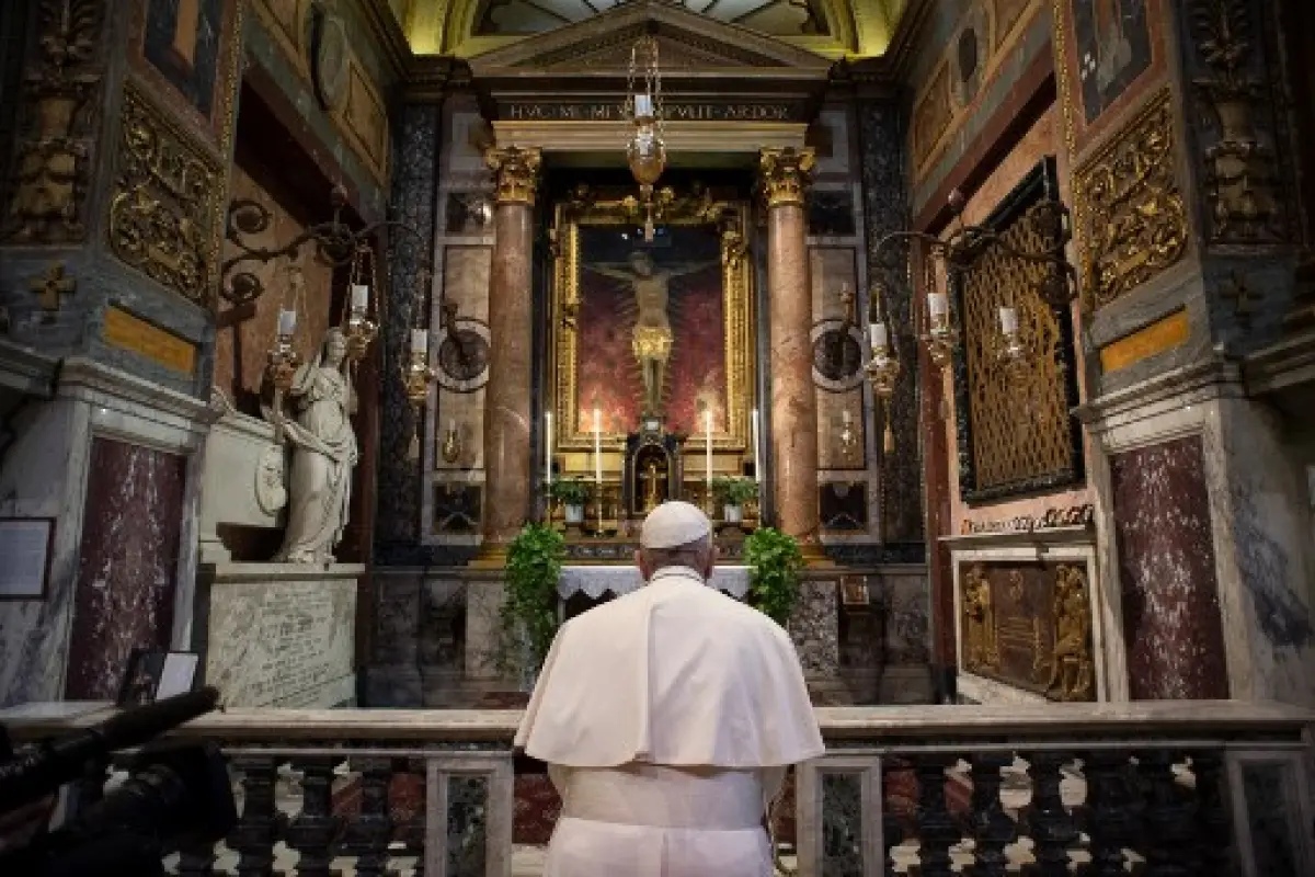 This handout picture released by the Vatican Media shows Pope Francis, in Rome on March 15, 2020, prays in S. Marcello al Corso church, where there is a miraculous crucifix that in 1552 was carried in a procession around Rome to stop the great plague. - T