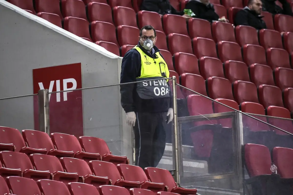 A photograph taken on March 12, 2020, shows a member of staff wearing a mask inside the empty stadium prior to the UEFA Europa League first leg of round-of-16 football match between Olympiakos FC and Wolves at the Karaiskakis Stadium, in Piraeus, near Ath