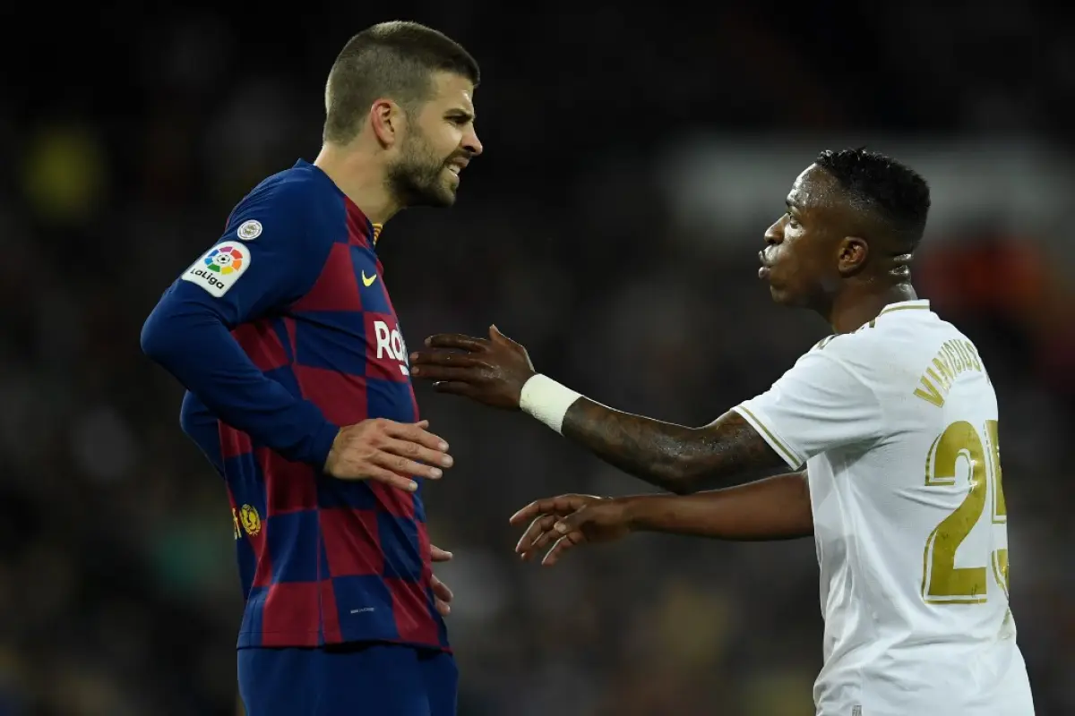 Barcelona's Spanish defender Gerard Pique (L) talks with Real Madrid's Brazilian forward Vinicius Junior during the Spanish League football match between Real Madrid and Barcelona at the Santiago Bernabeu stadium in Madrid on March 1, 2020. (Photo by OSCA