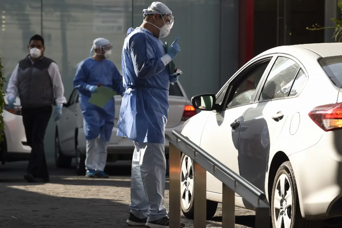 A doctor speaks with a person on a car as a questionnaire is done before the COVID-19 test at the Biomedica Lab in Mexico City on March 30, 2020. - Mexico's undersecretary of health prevention and promotion, Hugo Lopez-Gatell Ramirez, said the country was