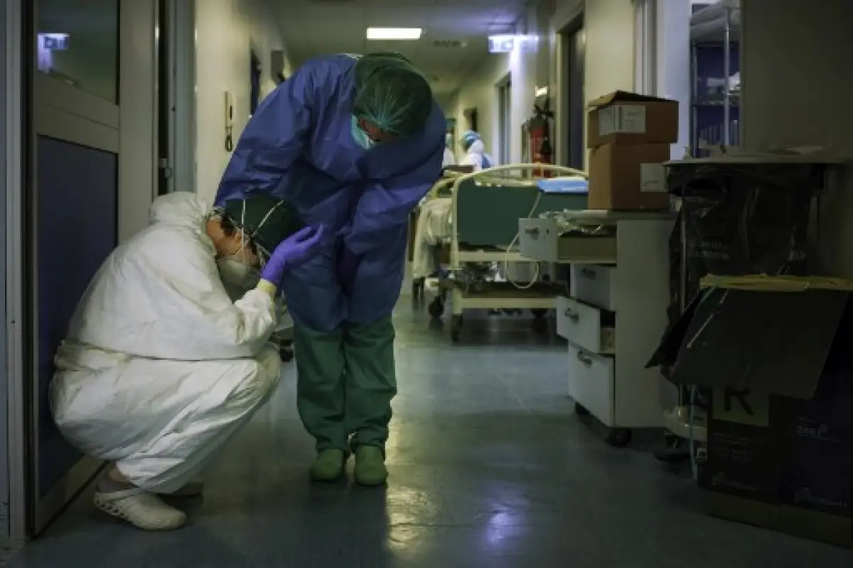 A nurse wearing protective mask and gear comforts another as they change shifts on March 13, 2020 at the Cremona hospital, southeast of Milan, Lombardy, during the country's lockdown aimed at stopping the spread of the COVID-19 (new coronavirus) pandemic.