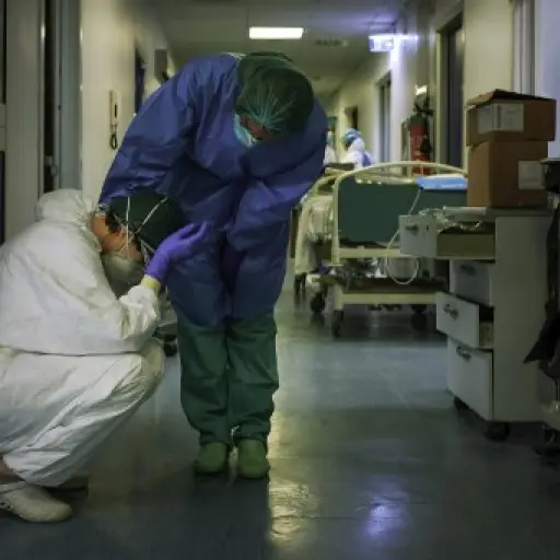 A nurse wearing protective mask and gear comforts another as they change shifts on March 13, 2020 at the Cremona hospital, southeast of Milan, Lombardy, during the country's lockdown aimed at stopping the spread of the COVID-19 (new coronavirus) pandemic.