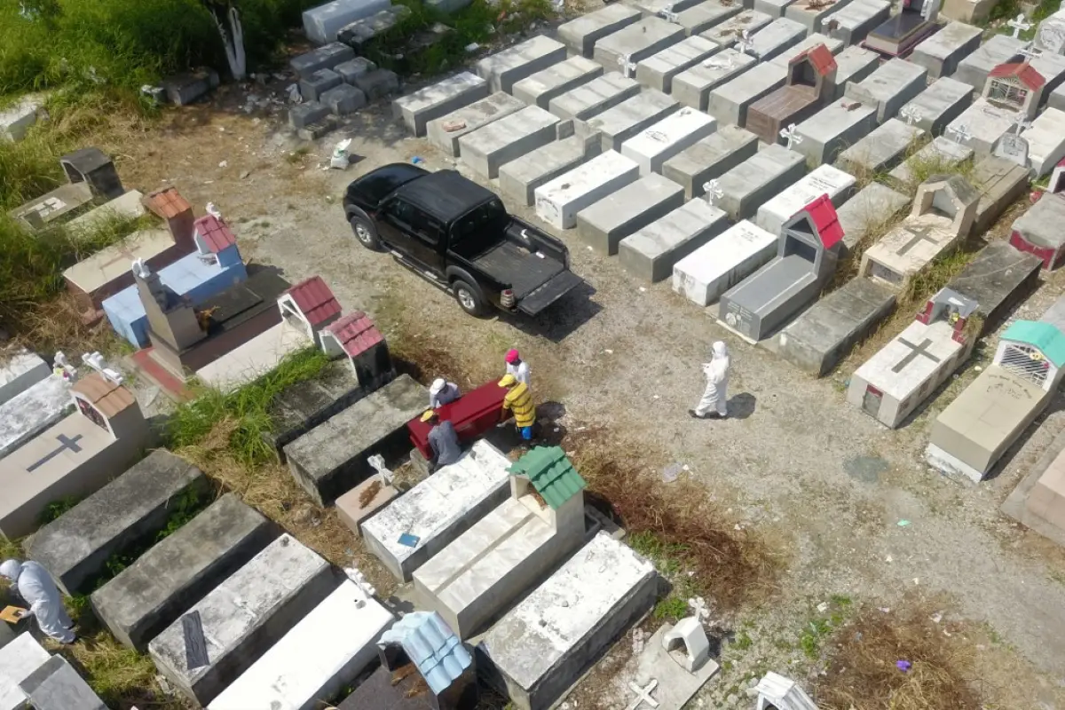 Aerial view of workers burying a coffin at Maria Canals cemetery in the outskirts of Guayaquil, Ecuador, on April 12, 2020, amid the new coronavirus outbreak. (Photo by Jose Sánchez / AFP)