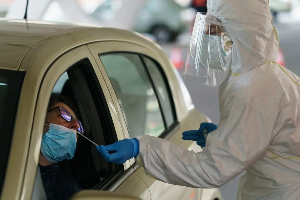 A healthcare worker dressed in protective gear takes samples from a driver at a drive-through testing point for the COVID-19 disease at the University Hospital in Burgos on April 18, 2020. - The death toll from the coronavirus in Spain, the country hit ha