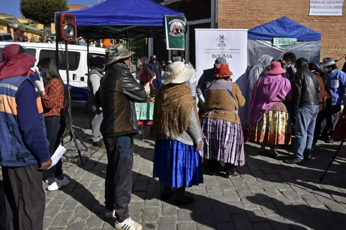 Locals queue to enter the first natural disinfection tunnel of medicinal plants, during the COVID-19 coronavirus pandemic, in El Alto, Bolivia, on April 15, 2020. - The Bolivian government extended the national quarantine for the coronavirus until April 3