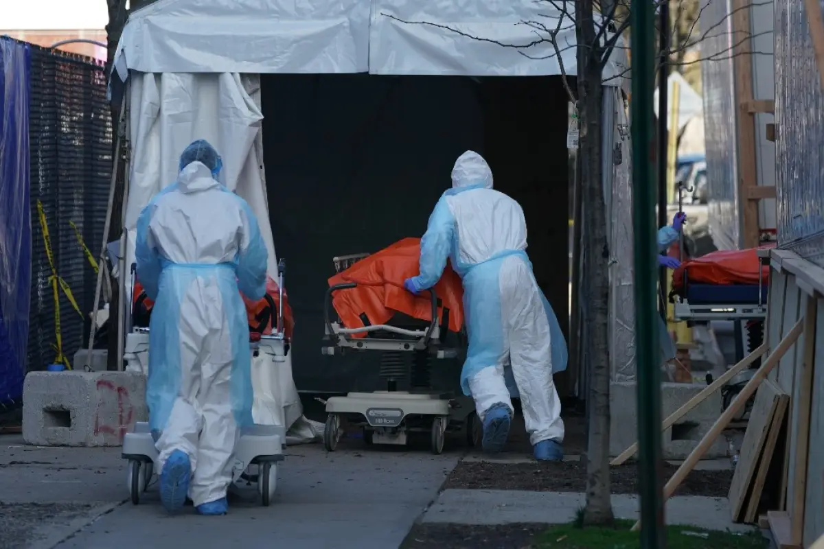 Bodies are moved to a refrigerator truck serving as a temporary morgue outside of Wyckoff Hospital in the Borough of Brooklyn on April 4, 2020 in New York. - New York state's coronavirus toll rose at a devastating pace to 3,565 deaths Saturday, the govern