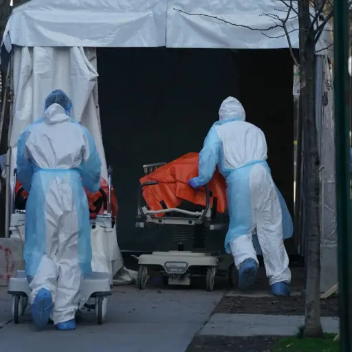 Bodies are moved to a refrigerator truck serving as a temporary morgue outside of Wyckoff Hospital in the Borough of Brooklyn on April 4, 2020 in New York. - New York state's coronavirus toll rose at a devastating pace to 3,565 deaths Saturday, the govern
