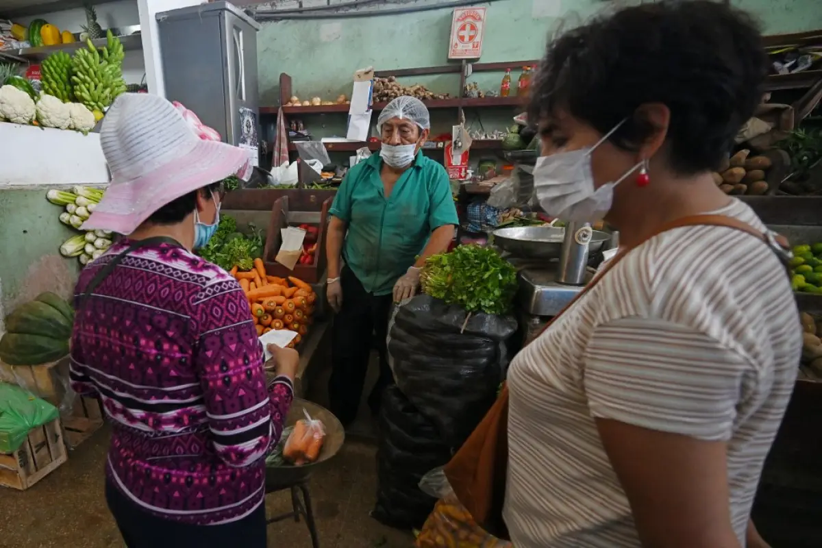 Shoppers wear face masks to prevent the spread of the new coronavirus at a neighborhood market in Lima, on April 2, 2020. - Peru reinforced on Thursday the circulation restrictions to control the coronavirus spread by prohibiting men and women from going 