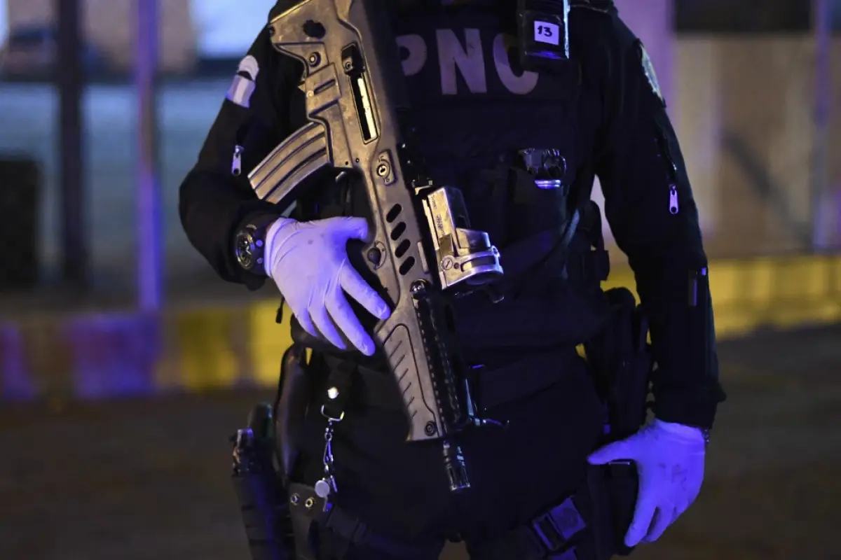 An armed police officer stands outside the new temporary hospital at Industry Park in Guatemala City on March 30, 2020 as members of the Guatemalan Red Cross transport fifteen patients infected with the new coronavirus (COVID-19) there from the hospital o