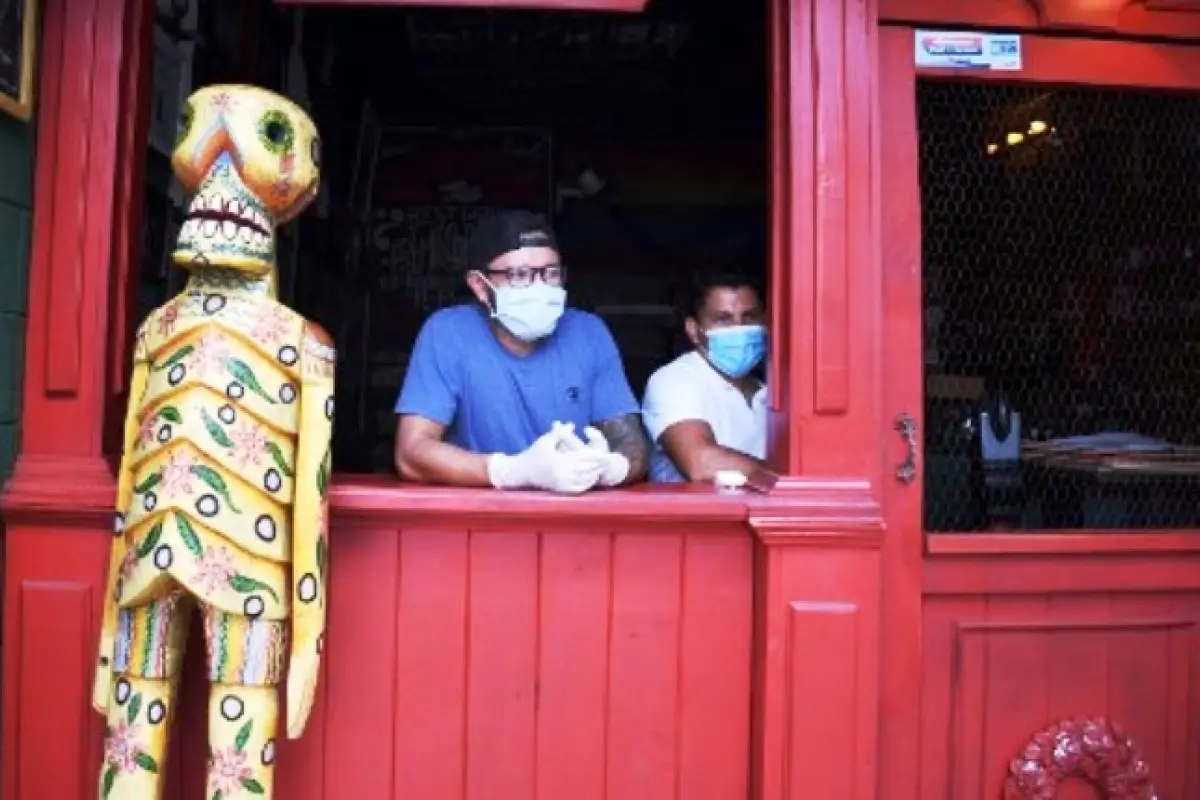 Volunteers wait to deliver food to people economically affected by the COVID-19 coronavirus outbreak, at the Rayuela Bar in Guatemala City on April 16, 2020. - In just over a week, the temporary dining room has gone from serving thirty people to prepare o