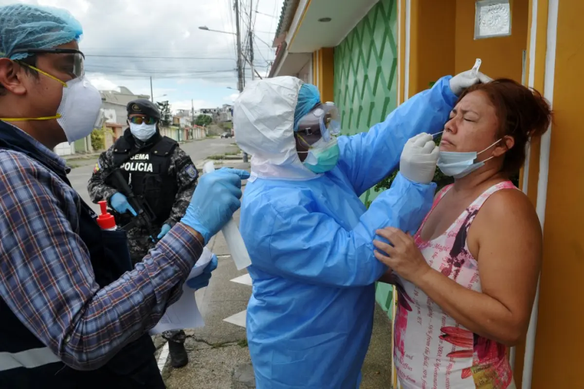 Health Ministry personnel test a woman for COVID-19 in the Samanes 7 residential complex in northern Guayaquil, Ecuador, during the coronavirus pandemic, on April 19, 2020. - Guayaquil, Ecuador's largest city, is the capital of Guayas province has recorde