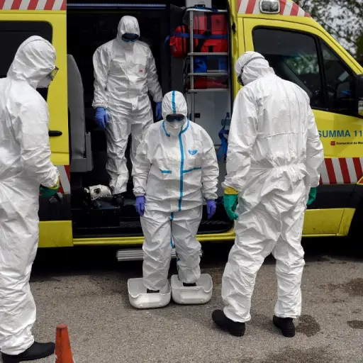 Healthcare workers of the Medical Emergency Services of Madrid (SUMMA 112) UVI-6 unit wearing protective suits arrive to get disinfected by firefighters at IFEMA in Madrid on April 19, 2020. - Spain imposed a tight lockdown on March 14 to slow the spread 
