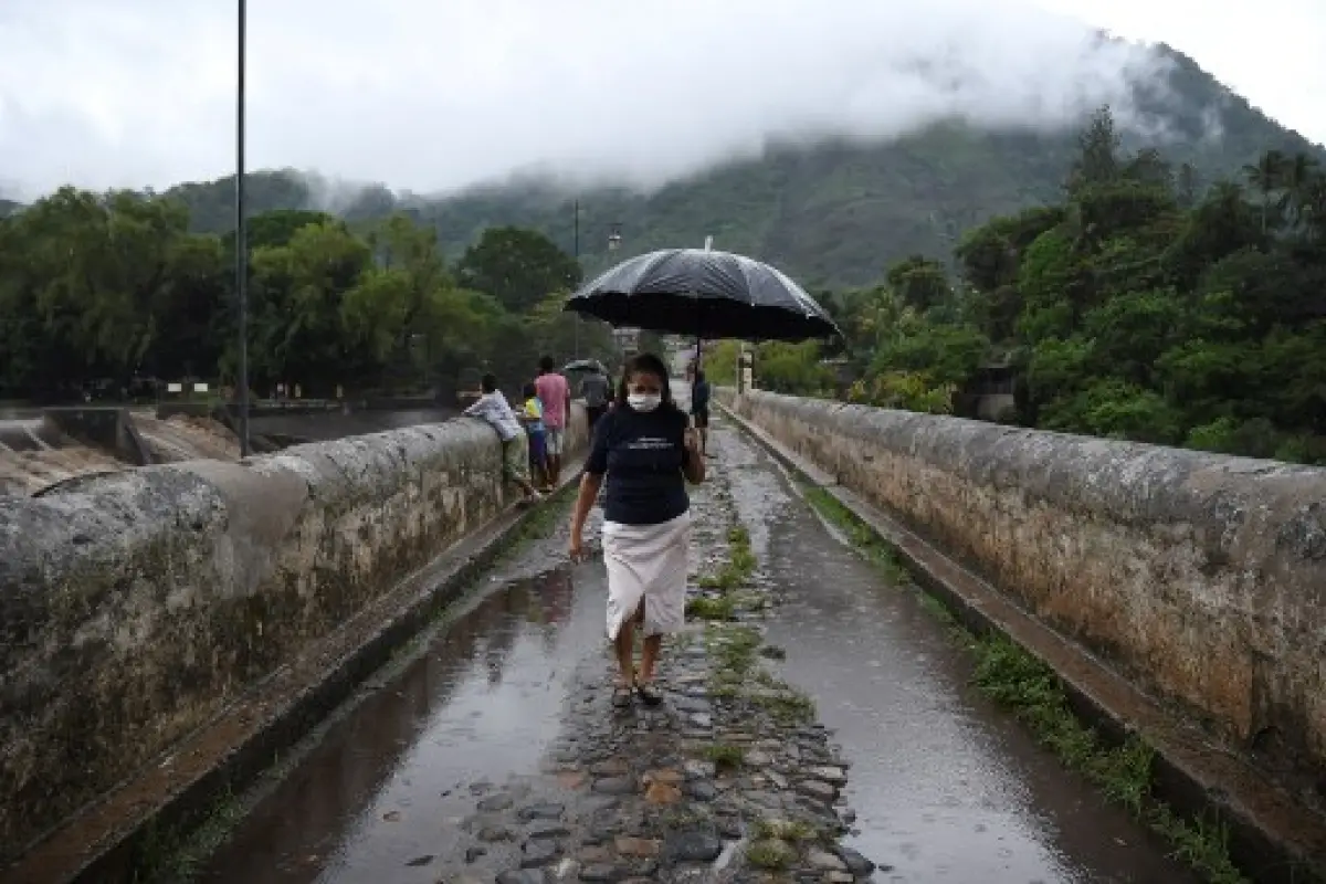 A woman walks across a bridge over Los Esclavos River during tropical storm Amanda, in Cuilapa, 65 km southeast of Guatemala City, on May 31, 2020. - Tropical storm Amanda, the first named storm of the season in the Pacific, lashed El Salvador and Guatema