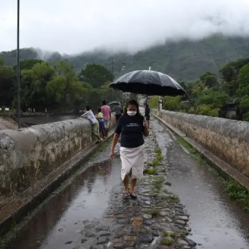 A woman walks across a bridge over Los Esclavos River during tropical storm Amanda, in Cuilapa, 65 km southeast of Guatemala City, on May 31, 2020. - Tropical storm Amanda, the first named storm of the season in the Pacific, lashed El Salvador and Guatema