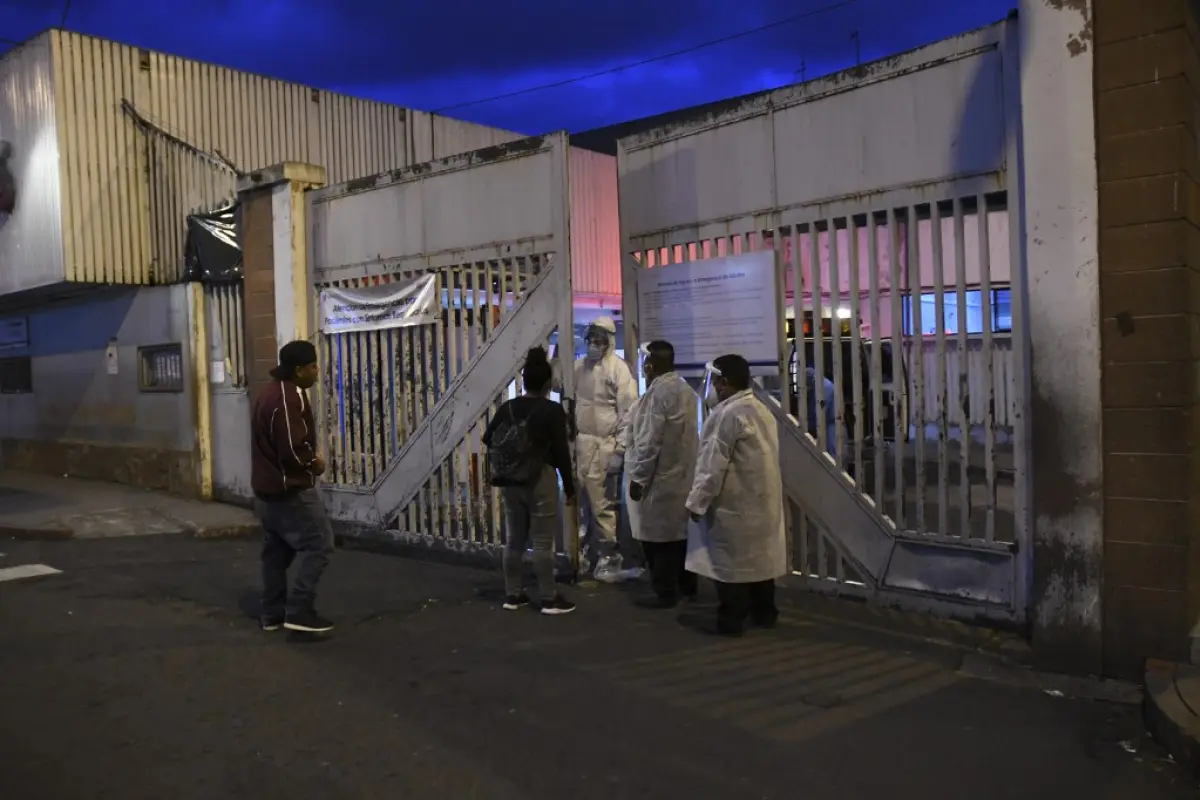 Relatives speak to medical staff after the transfer of a patient with symptoms related to novel coronavirus, at the COVID-19 unit of San Juan de Dios hospital in Guatemala City on June 12, 2020. - As of June 12, 2020 Guatemala reported more than 8,600 inf