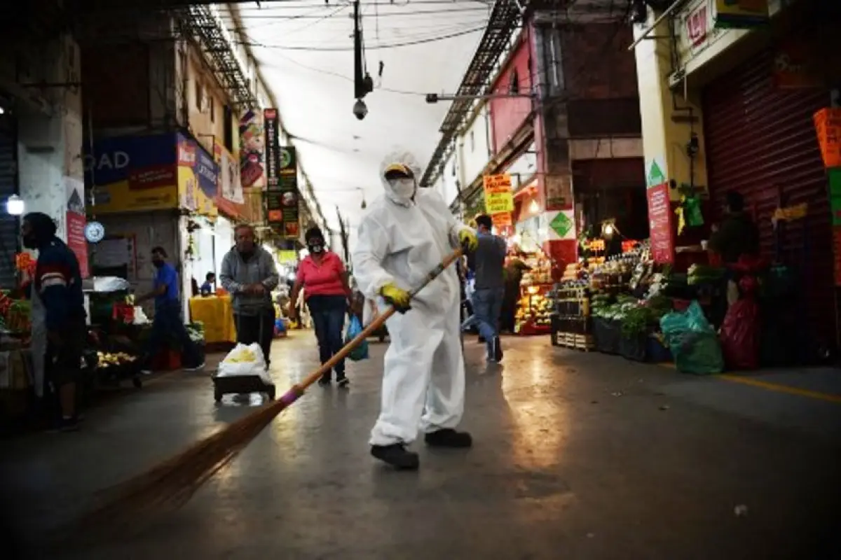 A workers wearing protective gear sweeps the floor sweeps the floor at the Central de Abastos market in Mexico City, on June 10, 2020 during the COVID-19 coronavirus pandemic. - The Central de Abastos (CEDA), the vast wholesale market in Mexico City that 