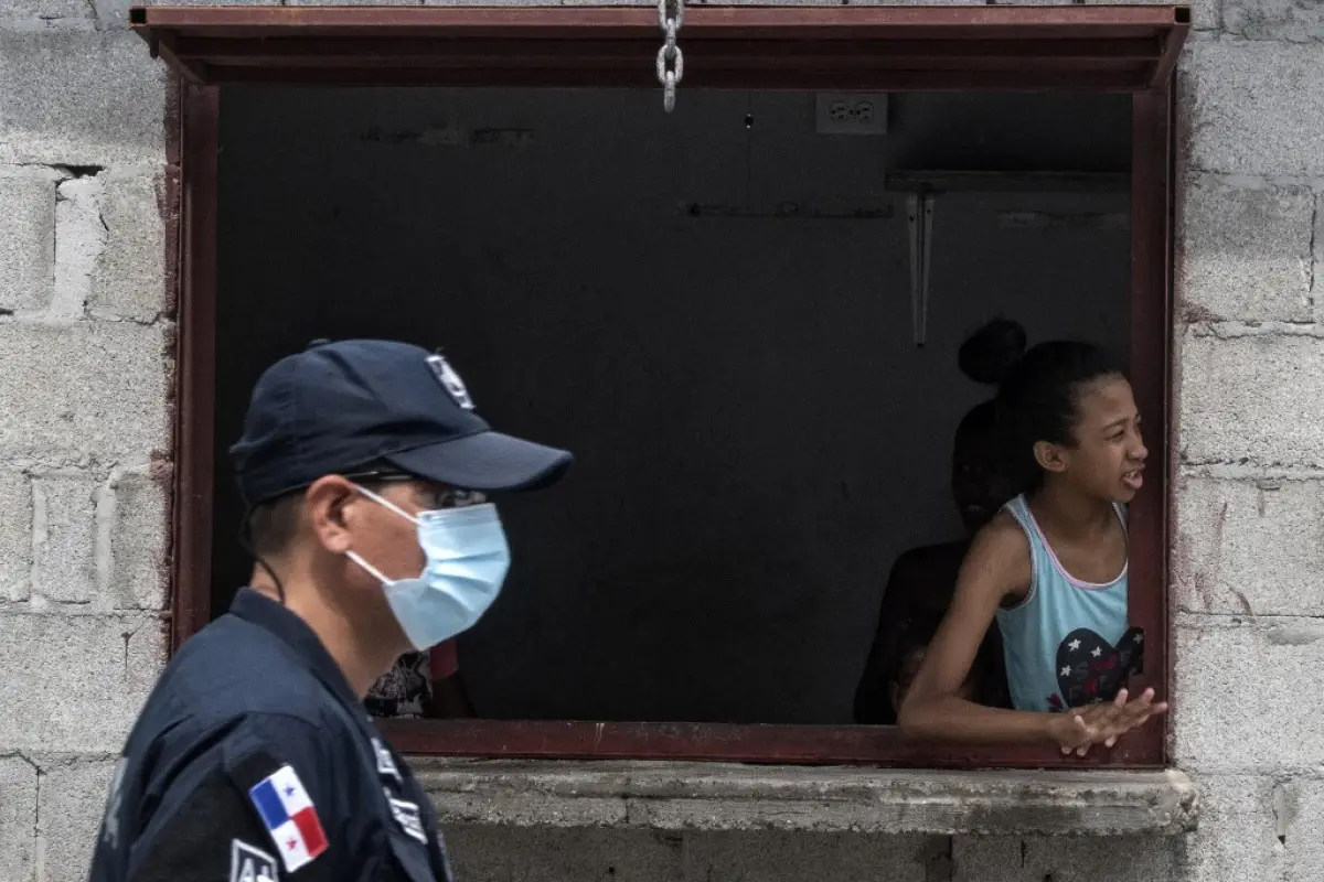 (FILES) In this file picture taken on April 1, 2020 a girl waits for bags of food being delivered by volunteers of "Panama Solidarity Plan" as an aid during the pandemic of the novel coronavirus, COVID-19 to low-income families at El Chorrillo neighbourho