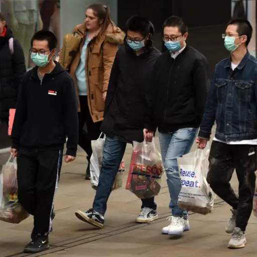 Shoppers wearing a protective facemasks walk through central Manchester on June 5, 2020, as lockdown measures are eased during the novel coronavirus COVID-19 pandemic. - Face coverings will soon be compulsory for people wanting to travel on public transpo