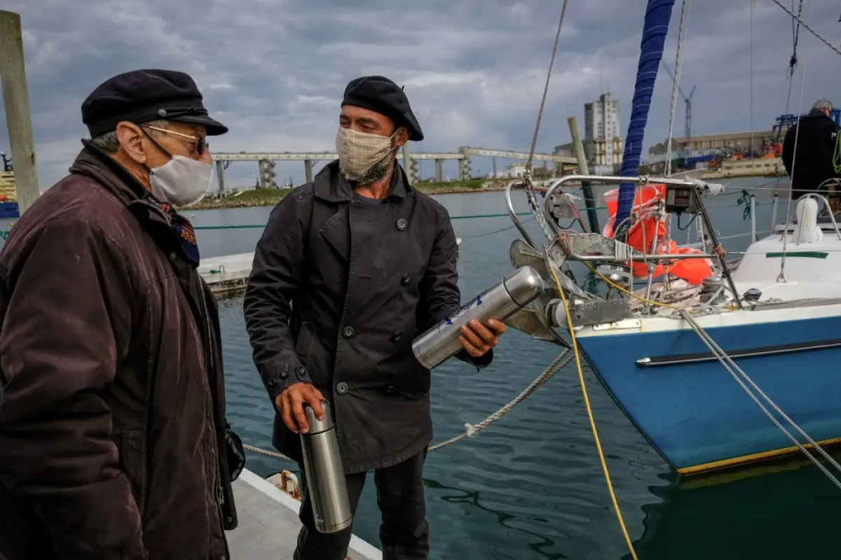 Handout picture released on June 21, 2020 by Telam, of Argentine Juan Manuel Ballestero (R) speaking with his father Carlos (L) upon arrival in Mar del Plata, from Portugal, on June 20, 2020, after sailing for 85 days due to the COVID-19 pandemic restrict