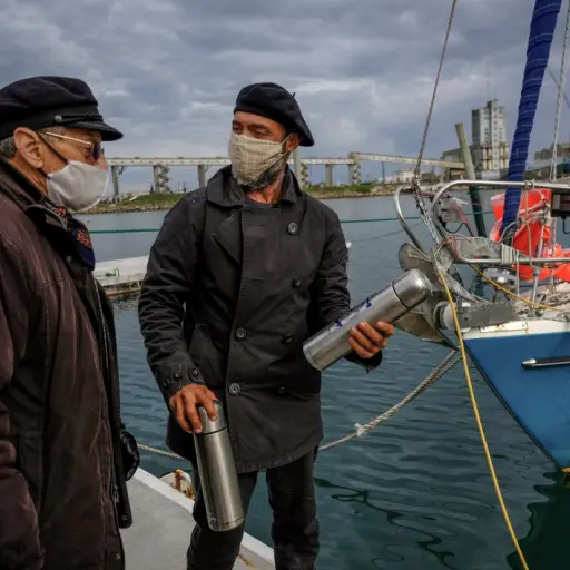 Handout picture released on June 21, 2020 by Telam, of Argentine Juan Manuel Ballestero (R) speaking with his father Carlos (L) upon arrival in Mar del Plata, from Portugal, on June 20, 2020, after sailing for 85 days due to the COVID-19 pandemic restrict