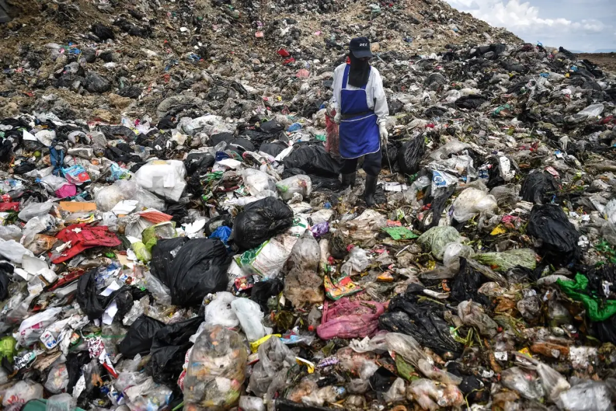 This photo taken on June 5, 2020 shows a garbage collector looking for recyclable plastic at the Ban Tarn landfill site in the northern Thai province of Chiang Mai. - Clogged canals and landfills, polluted rivers and seas, environmentalists warn Thailand'