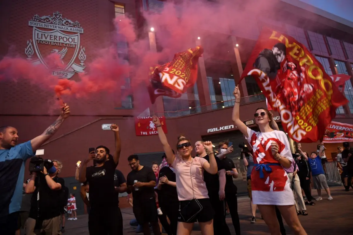 Fans celebrate Liverpool winning the championship title of the English Premier League outside Anfield stadium in Liverpool, north west England on June 25, 2020, following Chelsea's 2-1 victory over Manchester City. - Liverpool were crowned Premier League 