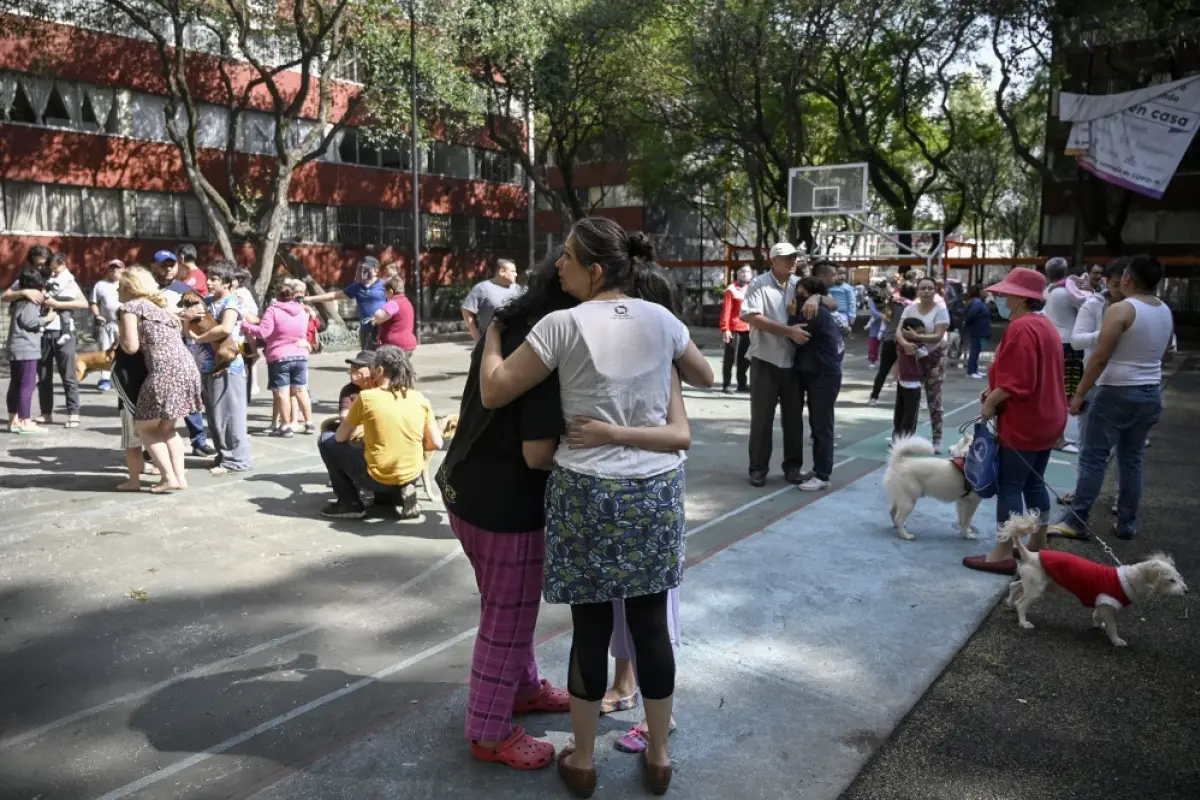 People remain outside buildings in Mexico City during a quake on June 23, 2020 amid the COVID-19 novel coronavirus pandemic. - A 7.1 magnitude quake was registered Tuesday in the south of Mexico, according to the Mexican National Seismological Service. (P